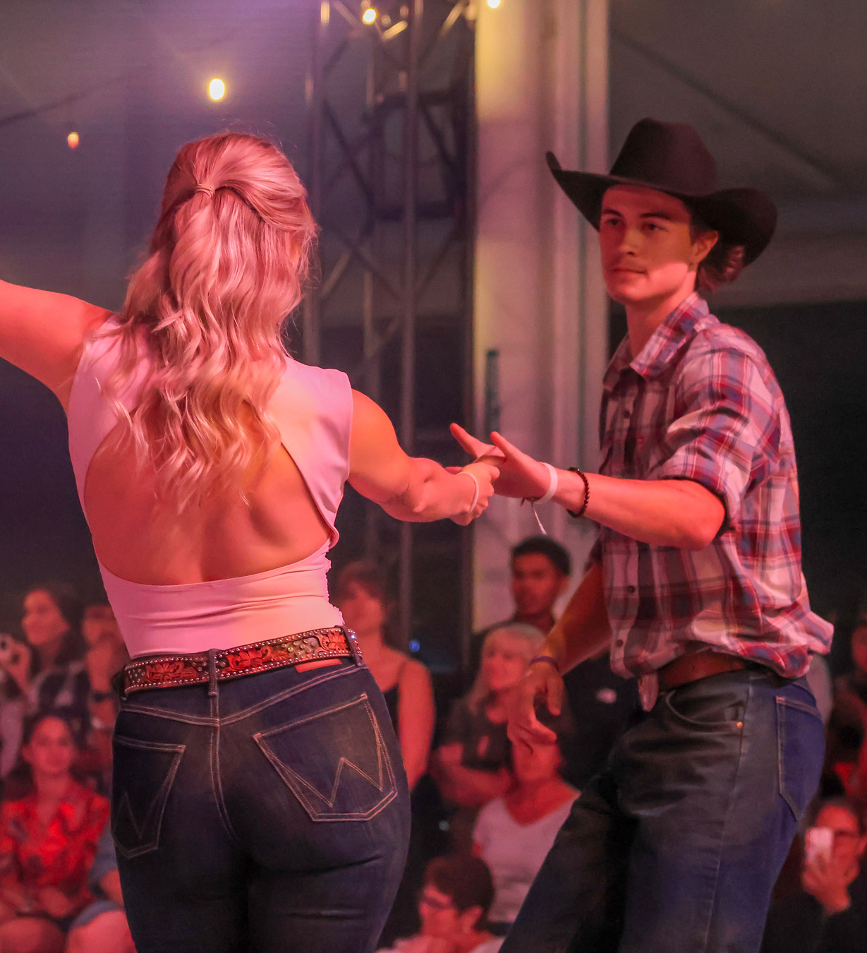Couple de danseurs de country engagé dans une performance passionnée sur la piste du circuit Bronco.